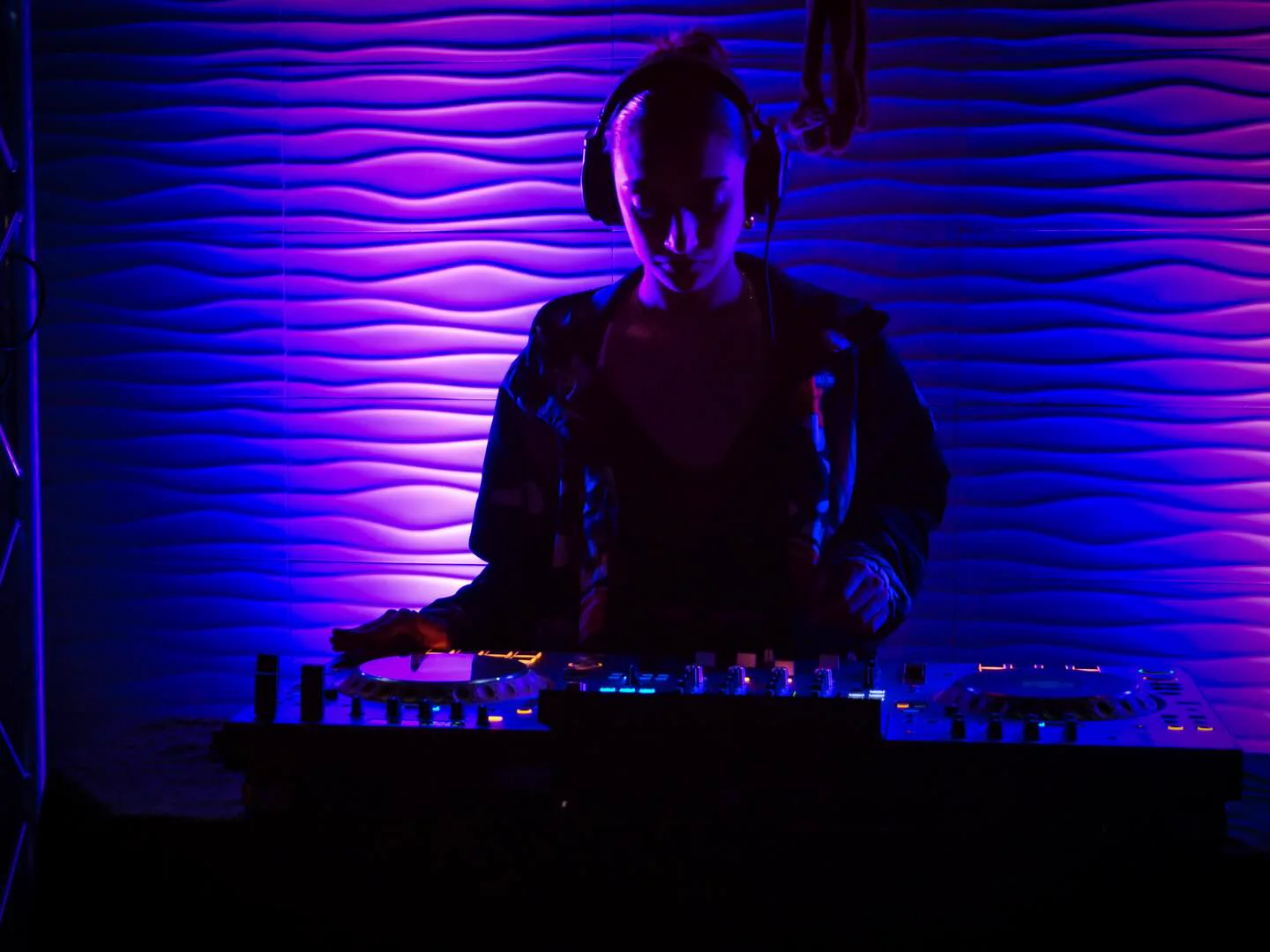 DJ tocando bajo luces violetas